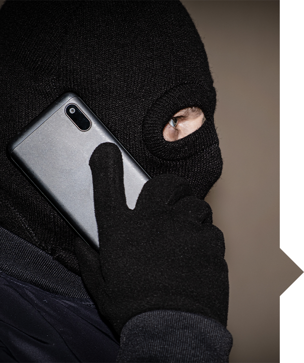 Person in black mask holding a phone